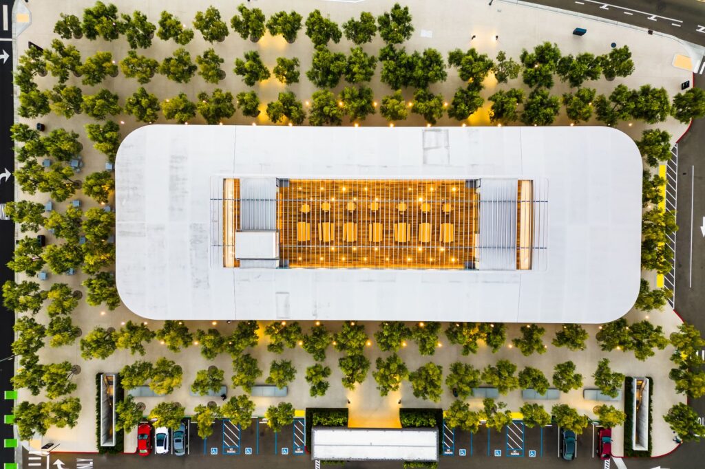 A stunning aerial shot of a modern building surrounded by trees, showcasing geometric architecture.