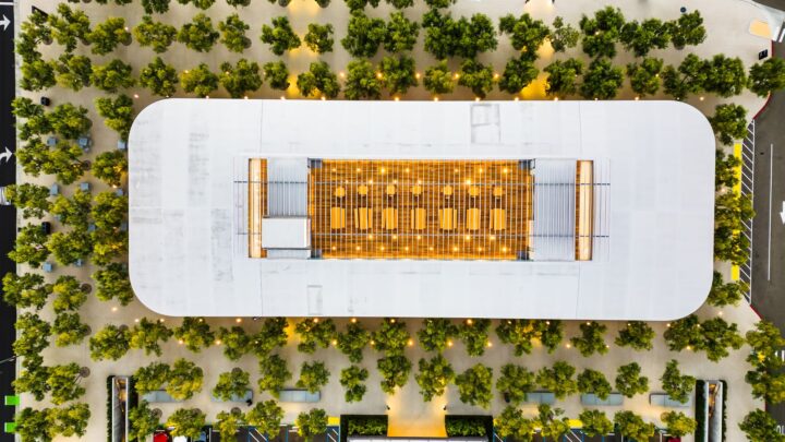 A stunning aerial shot of a modern building surrounded by trees, showcasing geometric architecture.