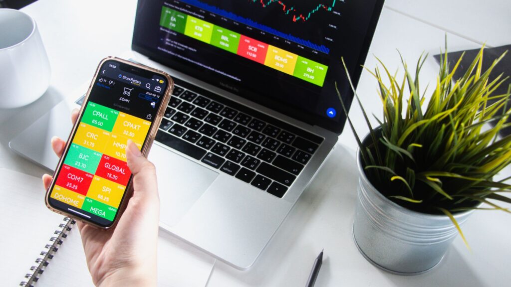 investor comparing gold ETF chart and physical gold pendant on table