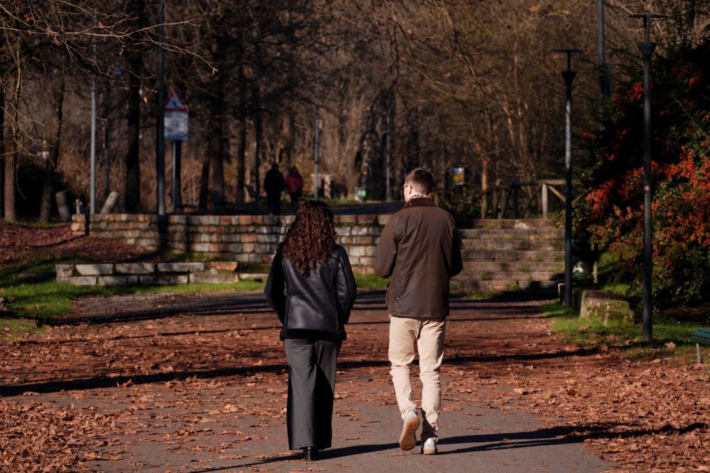 couple walking together in park autumn leaves relaxed atmosphere