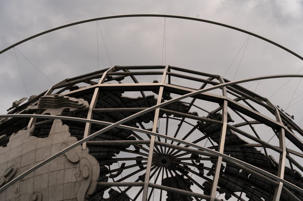 Detailed view of the Unisphere globe with overcast skies, showcasing intricate metal framework. 文章配图
