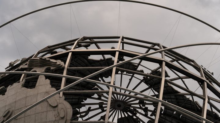 Detailed view of the Unisphere globe with overcast skies, showcasing intricate metal framework. 文章配图