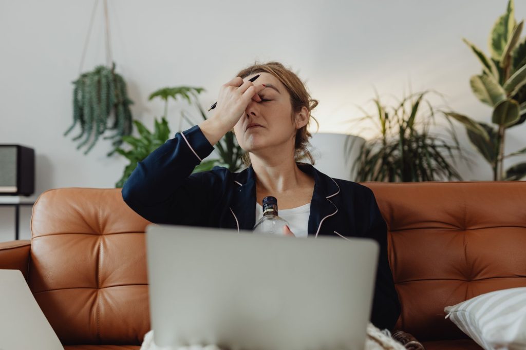 emotional exhaustion young woman sitting alone on sofa tired expression living room