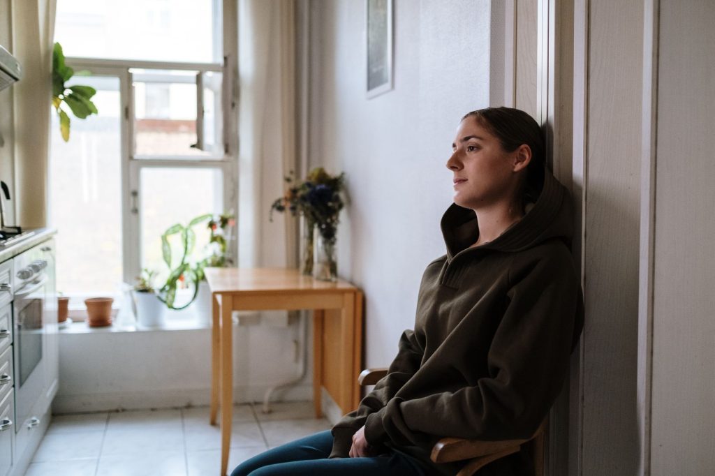 depressed person sitting in kitchen surrounded by junk food